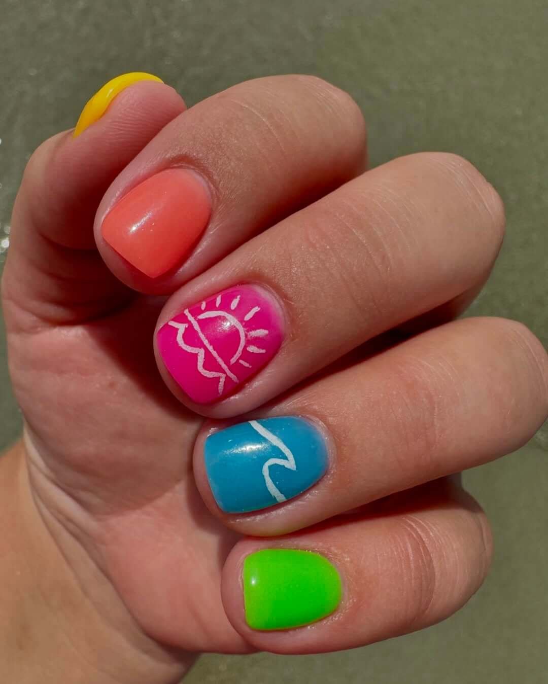 Rainbow nails with bright solids, doodle art, and vacation-themed colors for a fun tropical look.