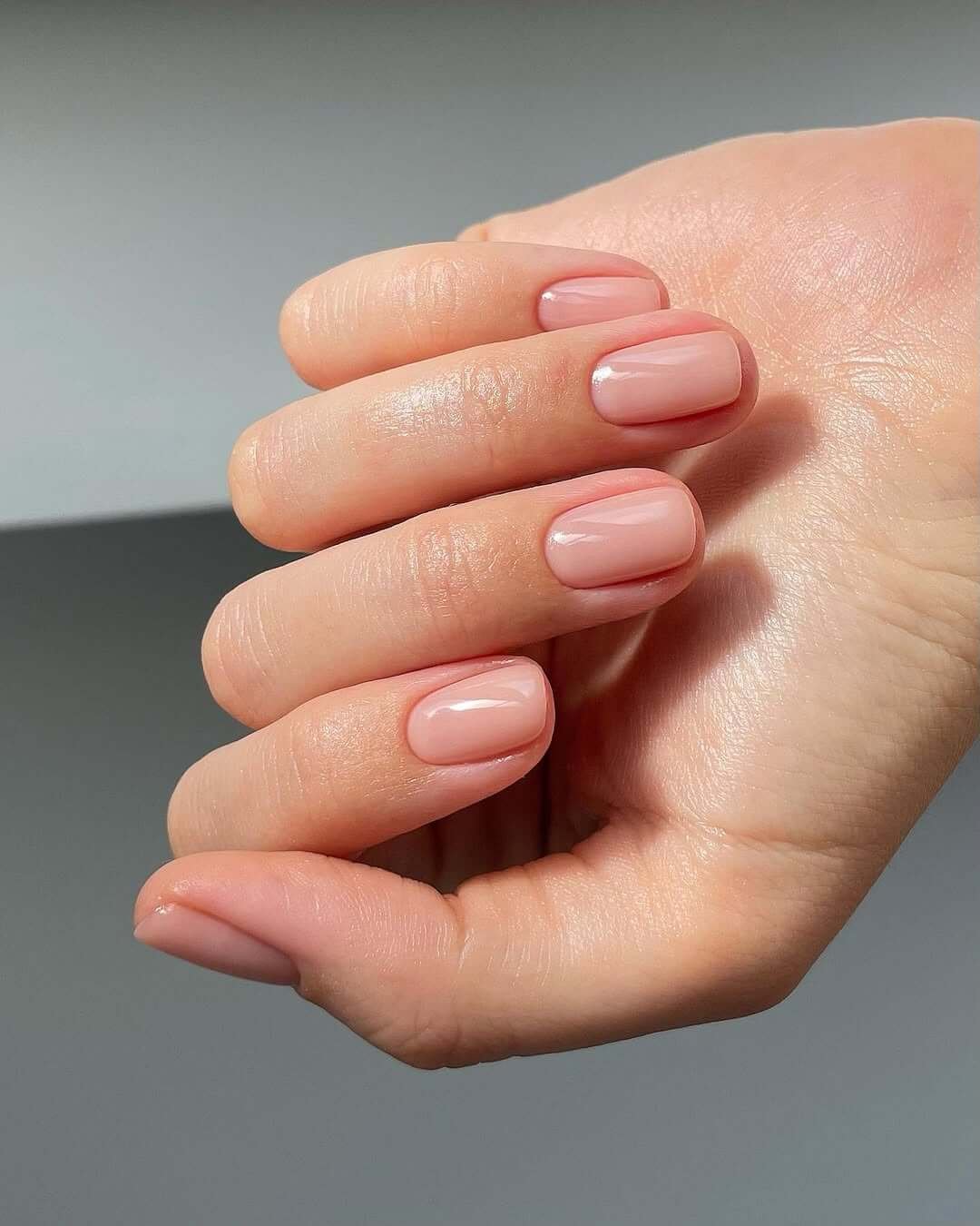 Short rounded nails in sheer blush nude for a minimalist, polished finish.