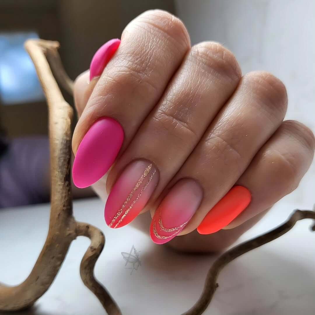 Unghie Sfumate almond-shaped nails with matte neon pink and orange ombré and fine glitter details for a bold summer vibe.