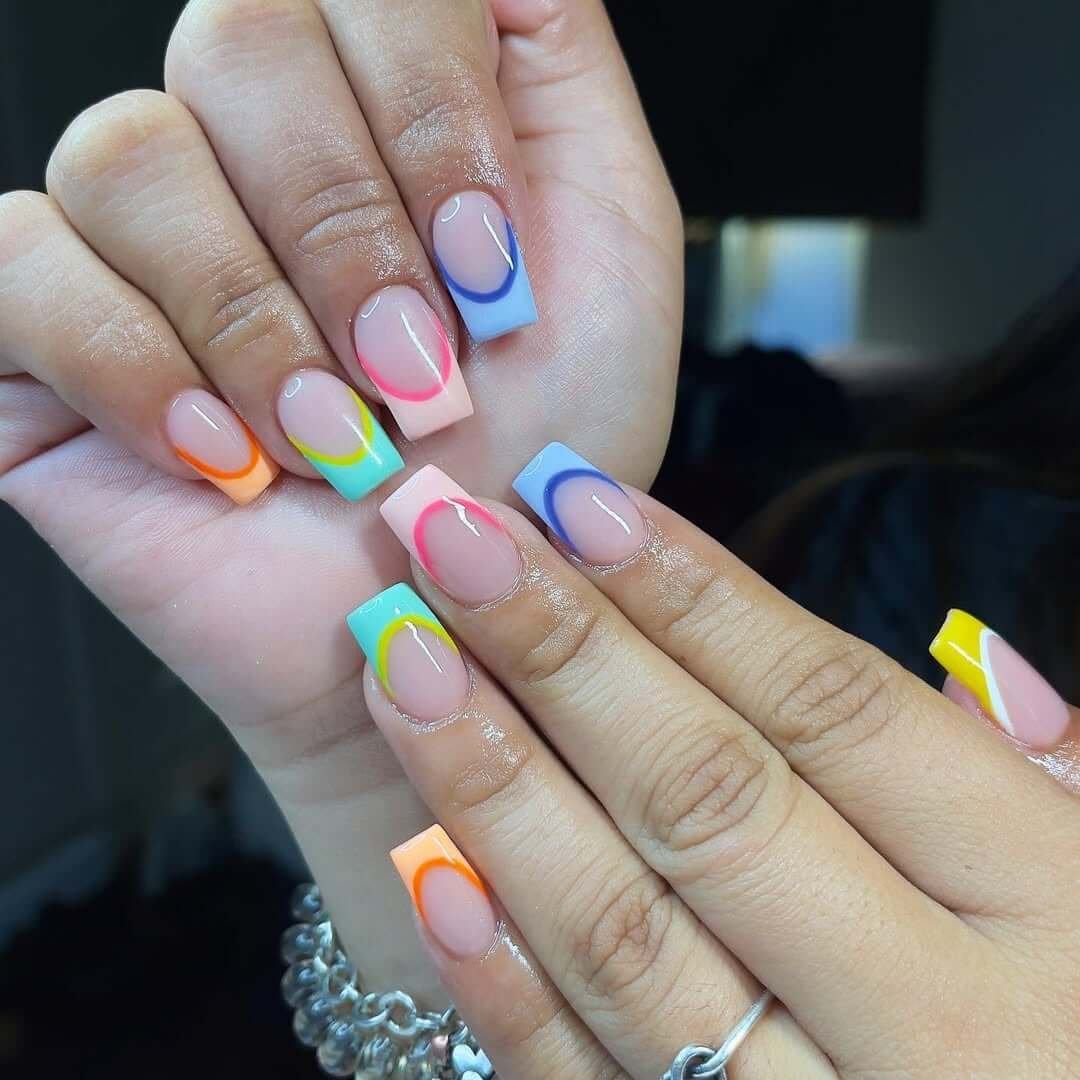 Short square nails with neon orange, pink, blue, and lime French arcs for a vibrant summer remix.
