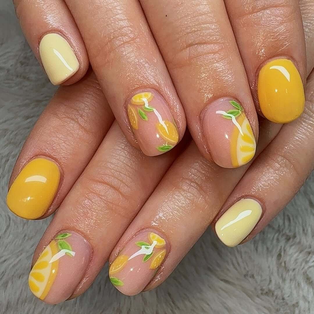 Short nails with yellow lemon slice art on a nude base for a juicy, fresh summer style.