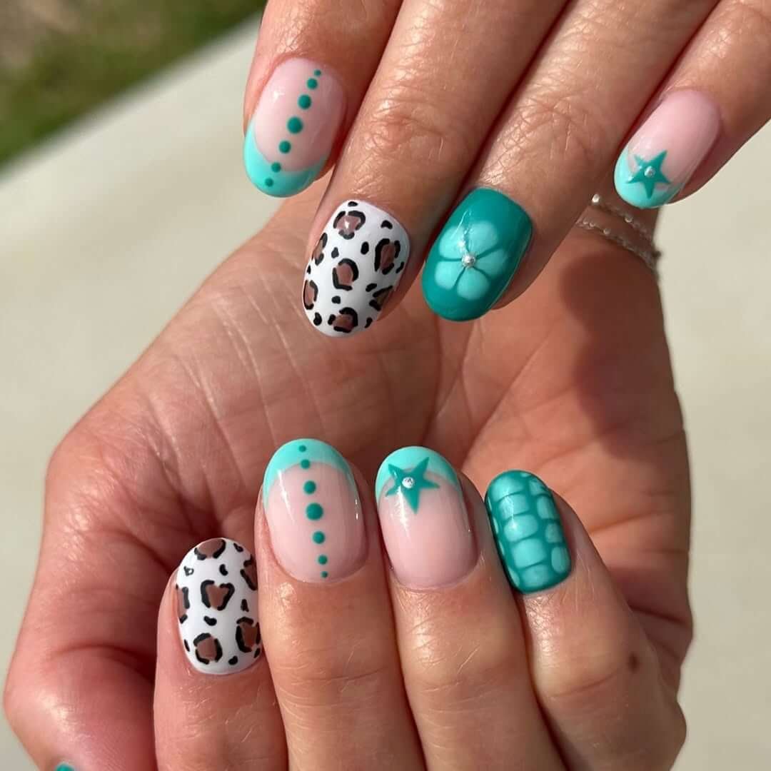 Nails with teal polish, 3D floral art, and leopard print accents for a fierce summer mix.
