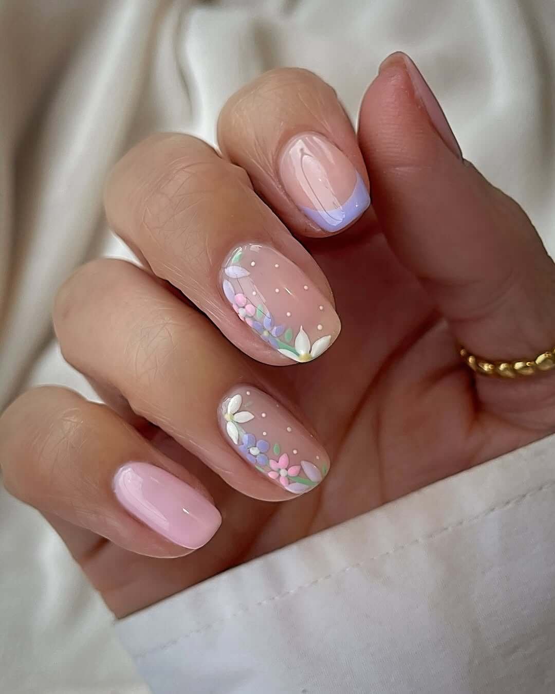 Biab short gel nails with lilac French tips and pastel floral art for a soft and sweet spring-inspired design.