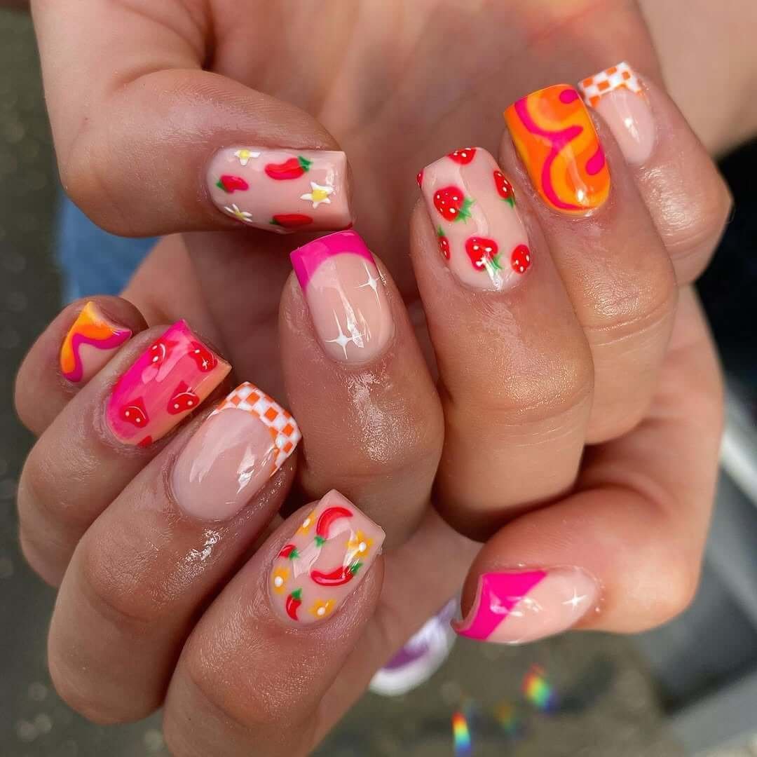 Square nails with strawberries, chili peppers, checkerboard tips, and swirls for a bold fruity look.